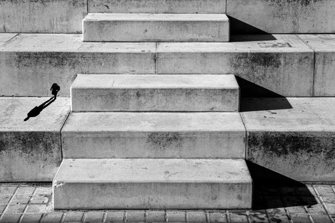 Escalones de concreto con sombras marcadas en blanco y negro.